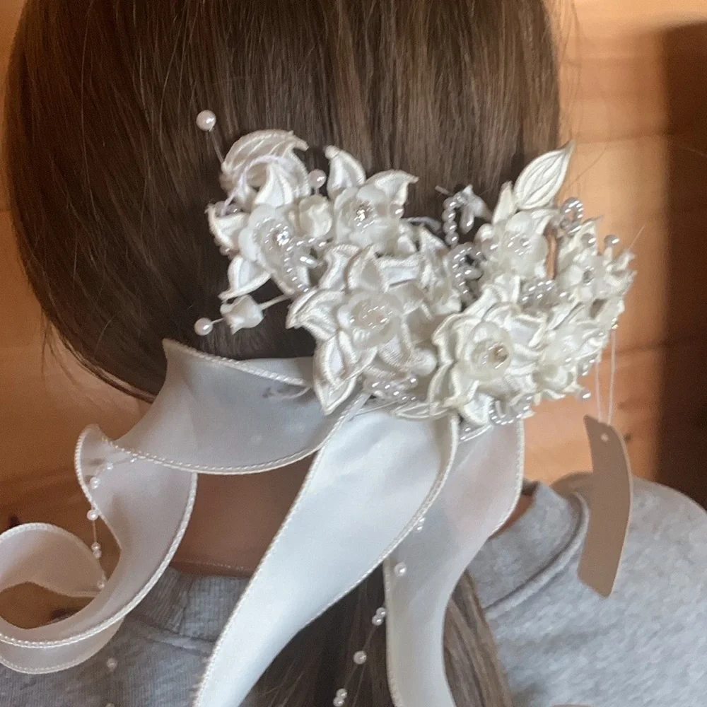 White floral and satin ribbon hairpiece with pearl and rhinestone detail